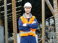 dono-de-loja-de-materiais-de-construcao-de-bracos-cruzados-usando-epi