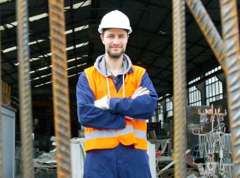 dono-de-loja-de-materiais-de-construcao-de-bracos-cruzados-usando-epi