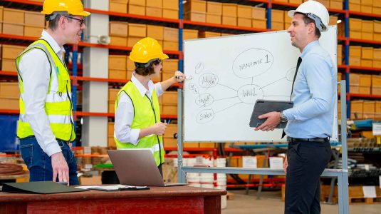 equipe-seguranca-planejando-gestao-riscos-gro-pgr Equipe de segurança do trabalho em reunião com quadro branco planejando a gestão de riscos, aplicando os conceitos do guia de GRO e PGR.