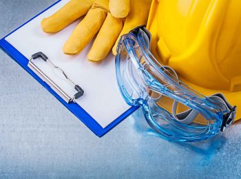 prancheta-de-checklist-ao-lado-de-capacete-amarelo-luvas-de-protecao-e-oculos-para-o-protocolo-de-fim-de-ano-de-seguranca-do-trabalho