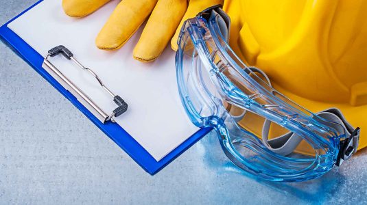 prancheta-de-checklist-ao-lado-de-capacete-amarelo-luvas-de-protecao-e-oculos-para-o-protocolo-de-fim-de-ano-de-seguranca-do-trabalho